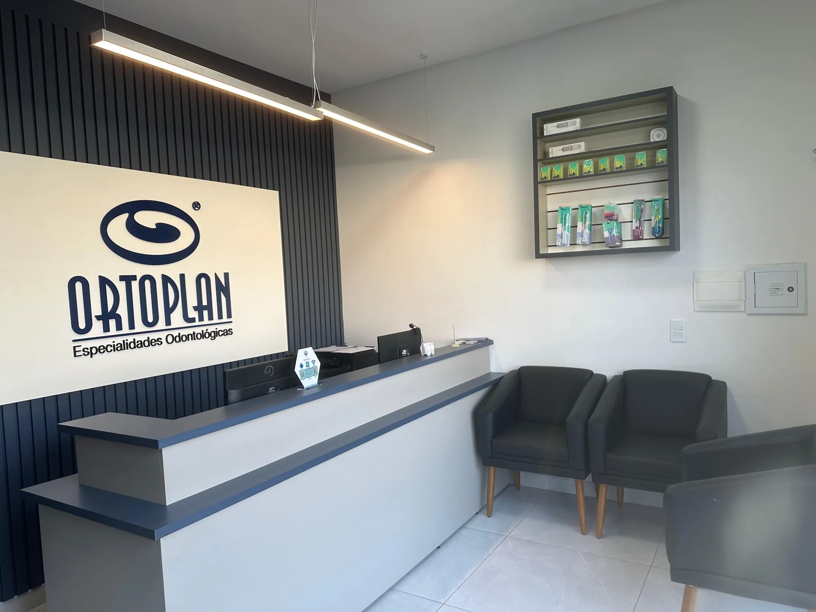 Recepção da Odontolatina Ortoplan Vila C, com poltronas e iluminação acolhedora